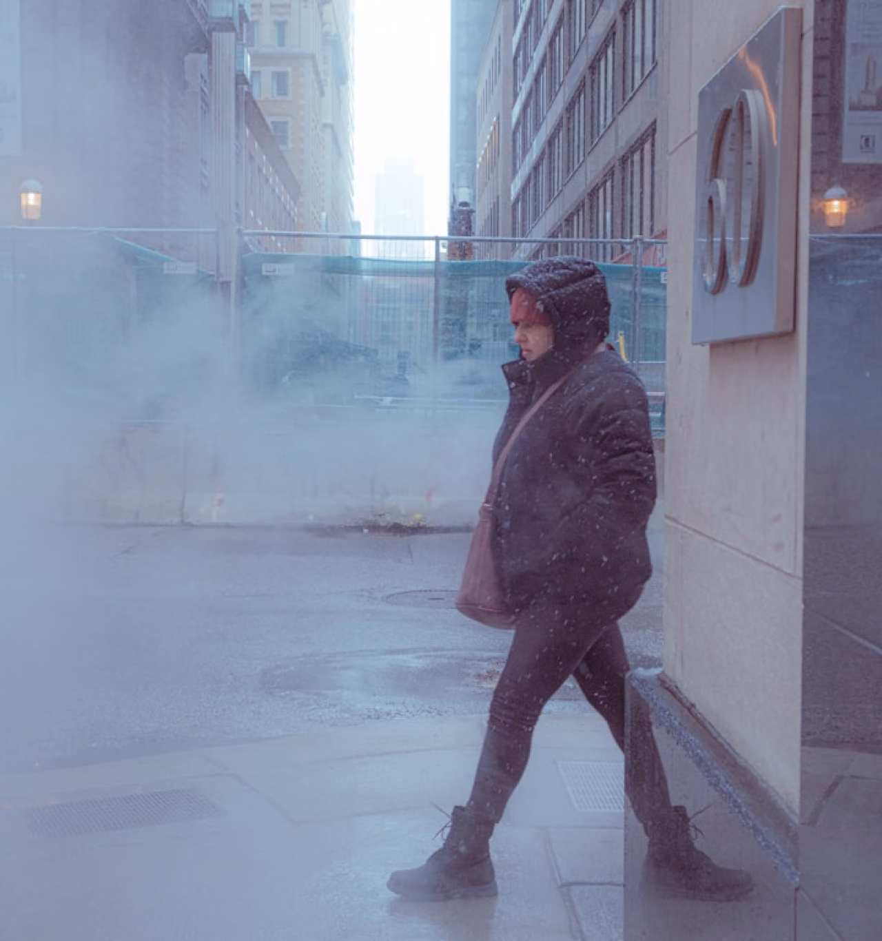 A person walking while it is snowing.